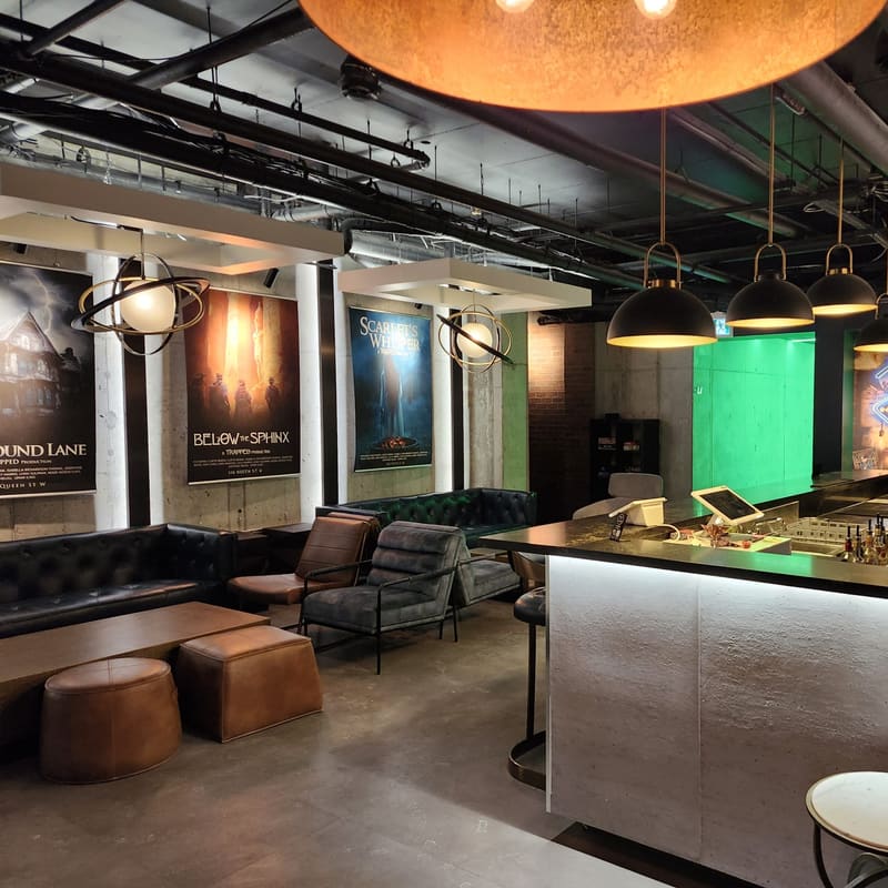 Leather couches under the room posters, green feature wall behind the bar
